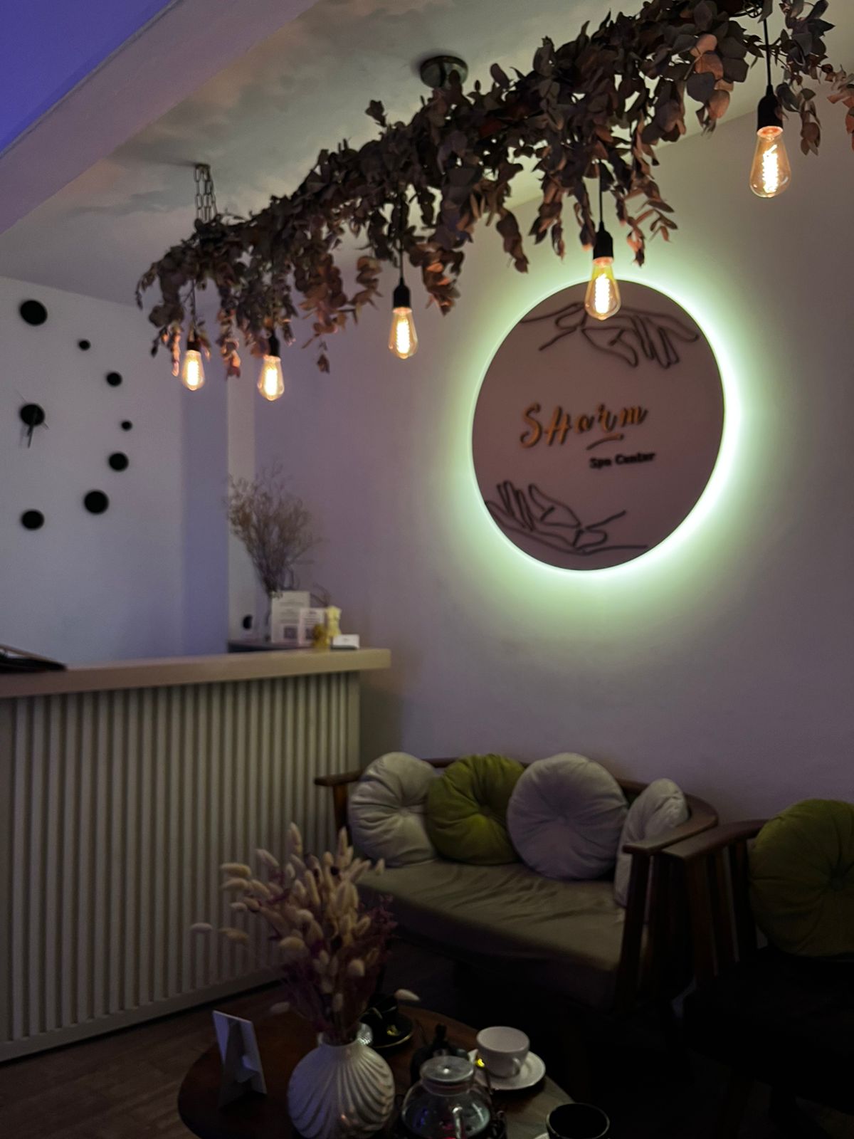 Cabina de masaje en SHarm Spa Center con ambientación cálida en tonos terracota, iluminación tenue de velas y camilla con mantas de lino